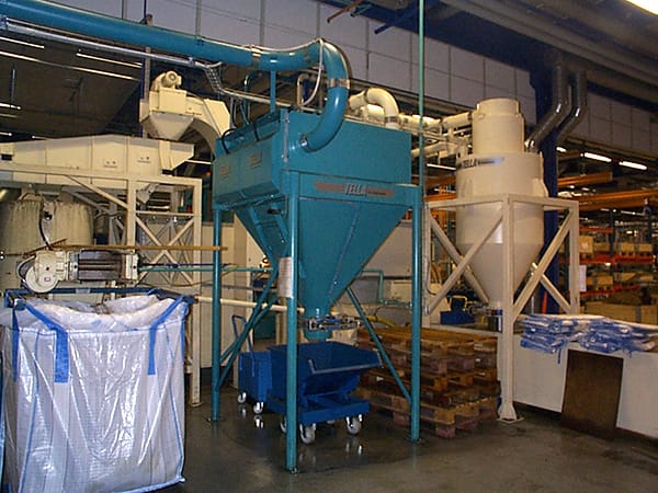 Installed BEASS filter separator system in an industrial facility, featuring conical tanks, ducting, and collection bags for pulse-cleaning and efficient airborne dust filtration.